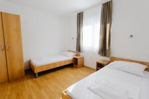 a small room with two beds and a window at Sobe Kozina in Međugorje