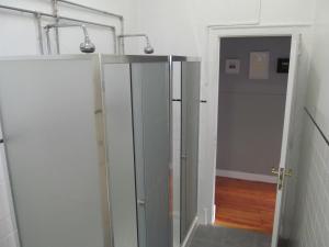 a bathroom with a walk in shower with a glass door at Casa Azul Hostel in Sintra