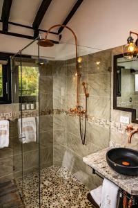 a bathroom with a glass shower with a sink at Casa Edmond in Villa de Leyva
