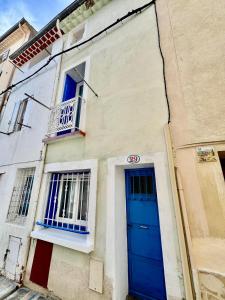 un edificio con una puerta azul y un balcón en Ostalet Blau Climatisé, en Béziers