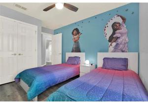 two beds in a bedroom with two mermaid pictures on the wall at 3157 YL - Encantada Serenity Retreat Elegant Villa Close to Disney in Kissimmee