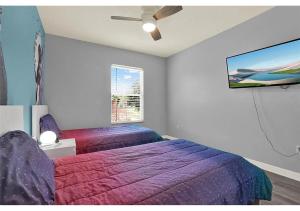 a bedroom with two beds and a flat screen tv at 3157 YL - Encantada Serenity Retreat Elegant Villa Close to Disney in Kissimmee