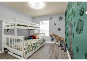 a childs bedroom with a giraffe mural on the wall at 3157 YL - Encantada Serenity Retreat Elegant Villa Close to Disney in Kissimmee +24 photos