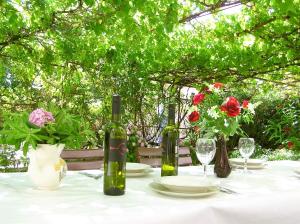 two bottles of wine sitting on a table with flowers at Holiday House Jure in Senj
