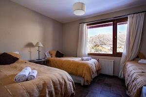a bedroom with two beds with towels on them at Bungalow en Cerro Catedral Ski in San Carlos de Bariloche