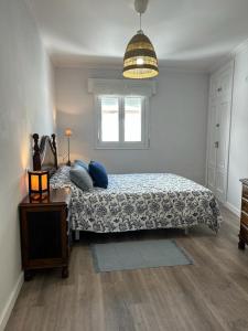 a bedroom with a bed with blue pillows and a table at Baiona Curuxa in Baiona