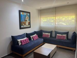 - un salon avec un canapé bleu et des oreillers roses dans l'établissement appartement luxueux laaida, à Sale