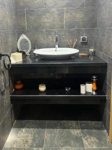 La salle de bains est pourvue d'un lavabo sur un comptoir noir. dans l'établissement appartement luxueux laaida, à Sale
