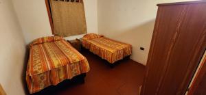 une petite chambre avec deux lits et une fenêtre dans l'établissement casa acogedora, à Melipeuco 9 autres photos