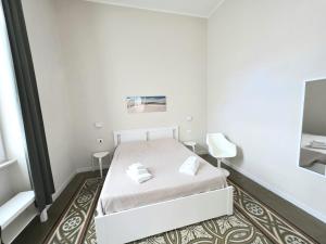 Dormitorio pequeño con cama blanca y espejo en Residenza La Terrazza locazione turistica, en Bari