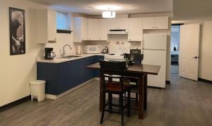 a kitchen with blue cabinets and a table with chairs at Entire Apartment in Guelph