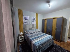 a small bedroom with a bed and a cabinet at Apto no Centro de São Leopoldo in São Leopoldo