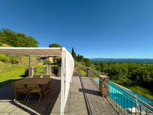 a wooden table and chairs under a canopy on a deck at Tenuta Panoramica sulle Colline Toscane in Paterna