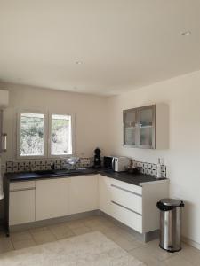 een keuken met witte kasten en een zwart aanrechtblad bij studio and large, beautiful pool in Saint-Ambroix