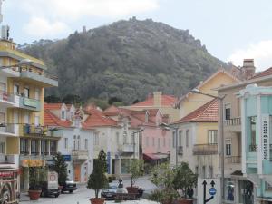 a city street with buildings and a mountain in the background at Casa Azul Hostel in Sintra