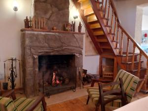 a living room with a fireplace and a staircase at myudro agaraki in Bagdatʼi +2 photos