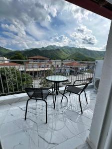 a patio with two chairs and a table on a balcony at Fintirik Cozy Stay in Stavros
