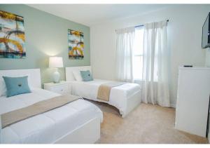 a white bedroom with two beds and a window at Fabulous 5BR Villa Marvel Private Pool - Solterra Retreat in Davenport