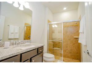a bathroom with a shower and a toilet and a sink at Fabulous 5BR Villa Marvel Private Pool - Solterra Retreat in Davenport +59 photos