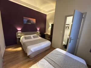 a hotel room with two beds and a mirror at Hotel Des Lices - Angers in Angers