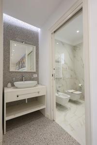 bagno bianco con lavandino e specchio di Nazzarì B&B Tropea a Tropea