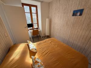 a bedroom with a bed and a desk and a window at Beautiful apartment in Tende Vallée des Merveilles in Tende