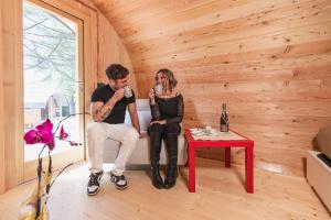 un uomo e una donna seduti in una stanza con un microfono di Rifugio DiVino - Dormire in una Botte - Esperienza unica di Glamping a Castelfranco Altre 37 foto