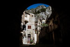 an entrance to a building with a mountain in the background at Incao Holiday Corso Umberto I in Cefalù
