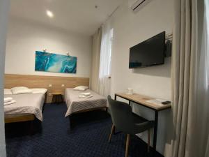 a hotel room with two beds and a television at Staryi Krakiv in Lviv