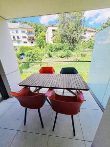 a wooden table and two chairs sitting on a patio at Beautiful Flat with garden view, terrace and parking-105 in Luxembourg
