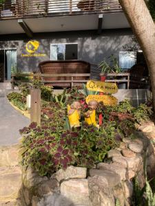 普腊亚罗萨Coração do Rosa - com Piscina Jacuzzi charme e conforto Pertinho do centrinho do Rosa的一个有两个玩具消防栓和一个标志的花园