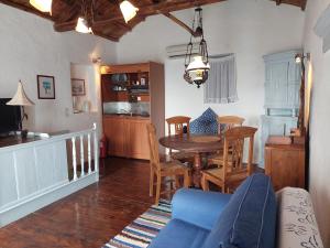 a kitchen and dining room with a table and chairs at Avra traditional Blue house, Elma's Houses in Alonnisos Old Town