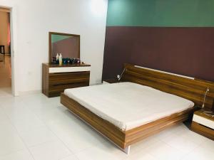 a bedroom with a bed and a dresser and a mirror at Appartement spacieux 3 chambres in Nouakchott