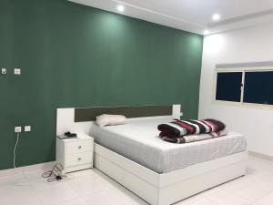 a bedroom with a bed with a green wall at Appartement spacieux 3 chambres in Nouakchott