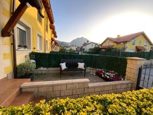 a patio with a bench and flowers in front of a house at UEFA Bilbao-Castro Urdiales home in Lusa