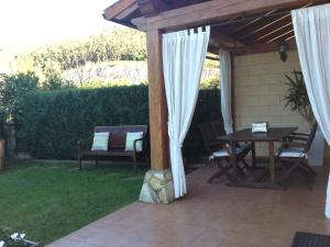 a wooden pergola with a table and chairs on a patio at UEFA Bilbao-Castro Urdiales home in Lusa
