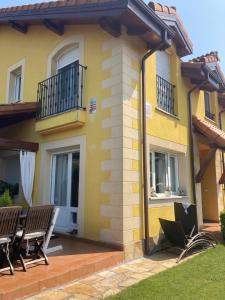 a yellow house with chairs on a patio at UEFA Bilbao-Castro Urdiales home in Lusa