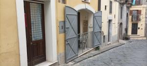 a pair of doors on a building on a street at Casa Nonna Trentina in Melfi