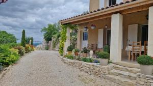 a house with plants on the side of a road at Le jardin des oliviers in Apt