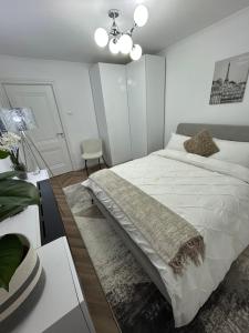 Un dormitorio con una cama blanca y una silla. en Romina b&b, en Hîrşova