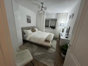 Un dormitorio blanco con una cama y un escritorio. en Romina b&b, en Hîrşova