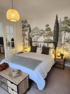 a bedroom with a large bed and a table at Au fil de l'eau - Balcon, Spacieux, Confort, Calme, Wifi in Camblain-Châtelain