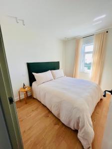 ein Schlafzimmer mit einem großen weißen Bett mit einem Fenster in der Unterkunft #OcéanoAtlántico in San Vicente do Mar