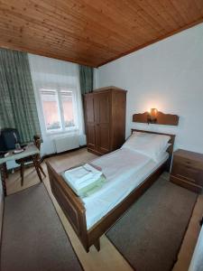 a bedroom with a bed and a desk with a computer at Hotel&Restaurant Gasthof zur Post Eisenerz in Eisenerz +120 photos