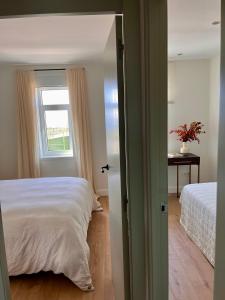 ein Schlafzimmer mit einem Bett und einem Fenster in der Unterkunft #OcéanoAtlántico in San Vicente do Mar