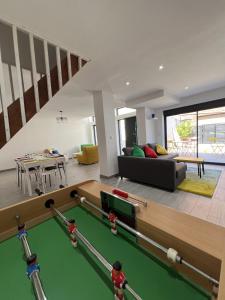a living room with a pool table and a couch at ValenStay - Maison groupes ou famille - Netflix in Anzin