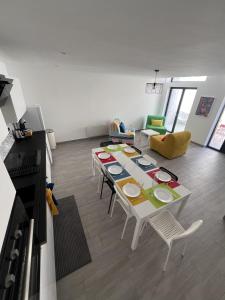 a living room with a table and chairs and a kitchen at ValenStay - Maison groupes ou famille - Netflix in Anzin