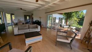 a living room with a couch and a table at Peaceful house in nature, with views of rolling hills in Bourail