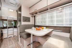 una piccola cucina e zona pranzo in un camper di Bauer Caravan in FKK Camping Solaris a Poreč (Parenzo)