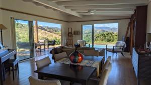 a living room with a table with a vase on it at Peaceful house in nature, with views of rolling hills in Bourail